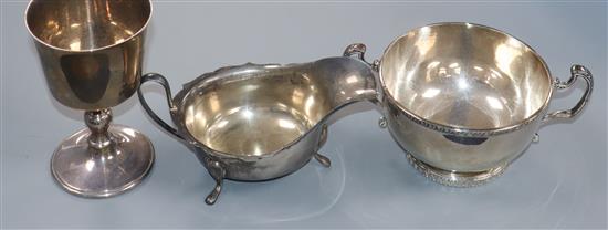 A George V silver sauceboat, a later silver goblet and a silver two handled bowl.